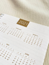Load image into Gallery viewer, made in jordan with italian high quality paper assembled and printed in jordan by local artisans journal meditative writing journaling morning ritual notebook calendar 2021 2022 lined paper gold shimmer letters to my self A5 size mindful lifestyle slow living