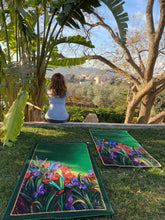 Load image into Gallery viewer, Artists self expression canvas inspired to convey the soul connection of mind body and soul. Empowering artists and artisans. Hand painted hints of gold scattered throughout the serenity mat. The artisanal redefinition of prayer and meditation mats. Life serenity mat by Fairuz Hamad. Nature flowers colors a garden of connection and consciousness. Woman outdoor meditating in garden scene. made in jordan